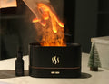 Diffuseur BRAISE Bureau noir avec flamme et brume, à côté d'un flacon d'huile essentielle