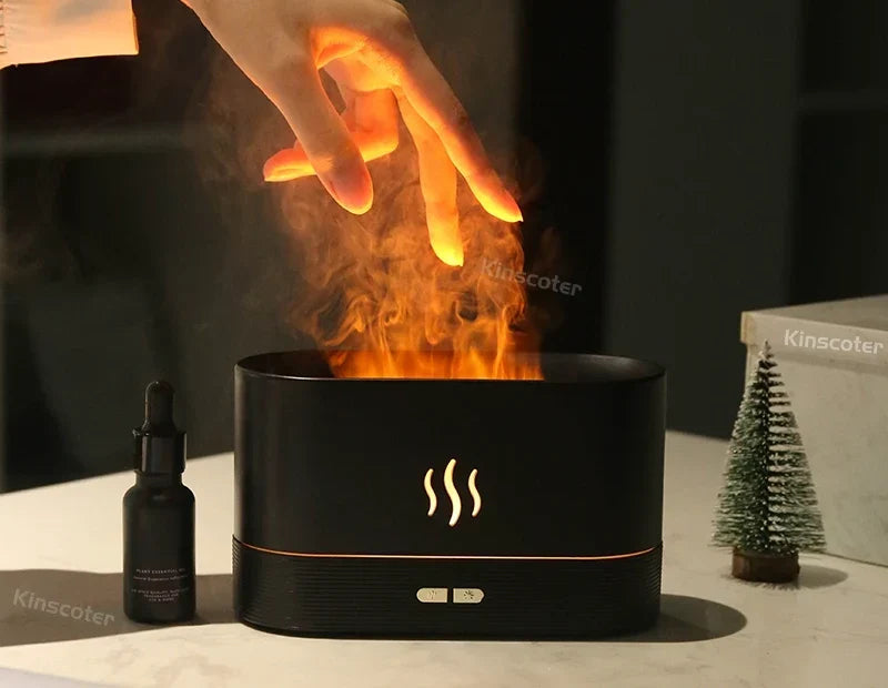 Diffuseur BRAISE Bureau noir avec flamme et brume, à côté d'un flacon d'huile essentielle